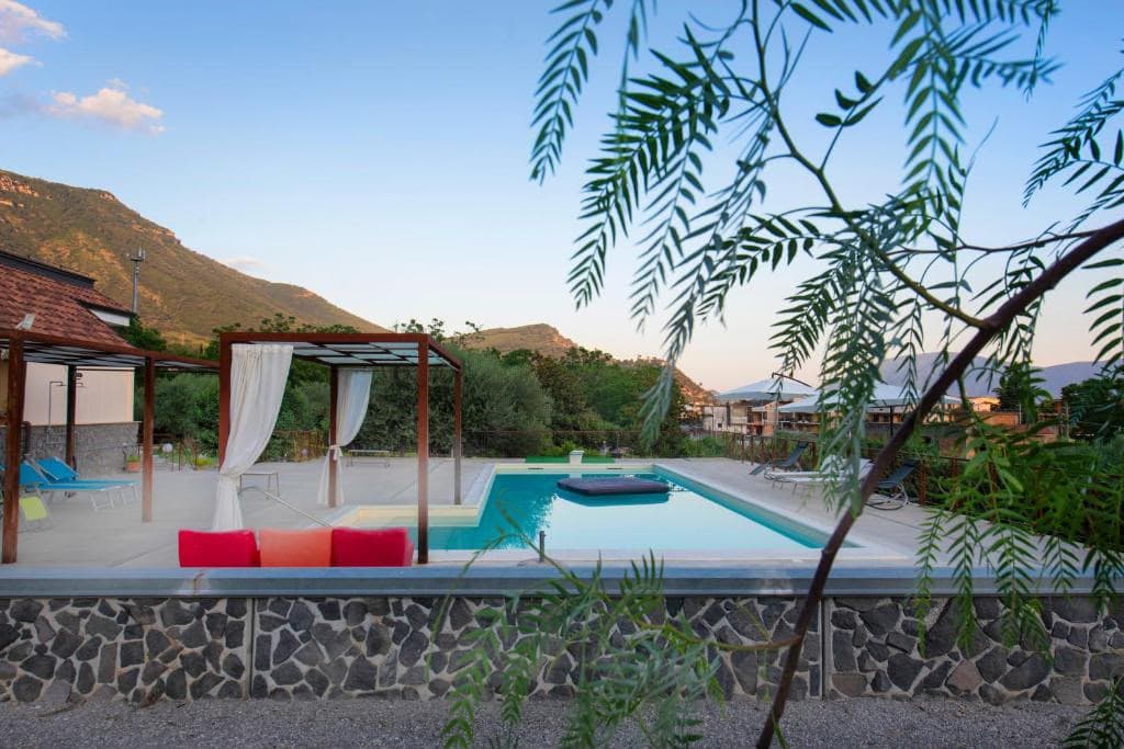 La piscina e il solarium tra il verde del giardino